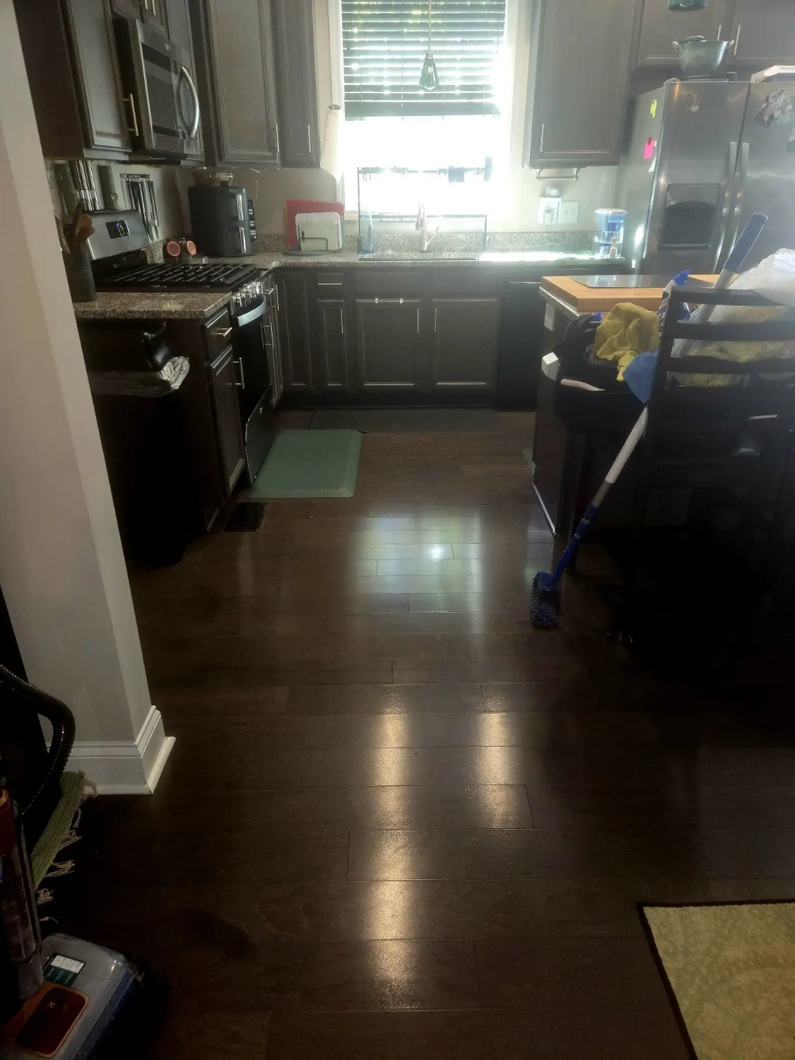 Deep brown clean hardwood flooring near a kitchen